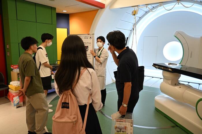 回転ガントリー照射室にて説明を受ける参加者